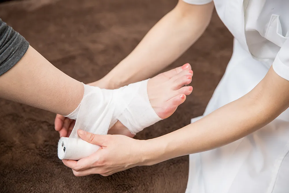 足に包帯を巻かれる様子
